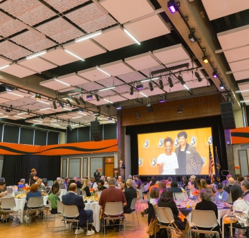 Social Hall with event attendees and video screen