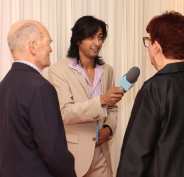 Student with microphone interviewing attendees