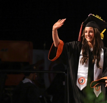 Female graduate walking across stage