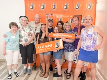 Group of people holding Alumni signs