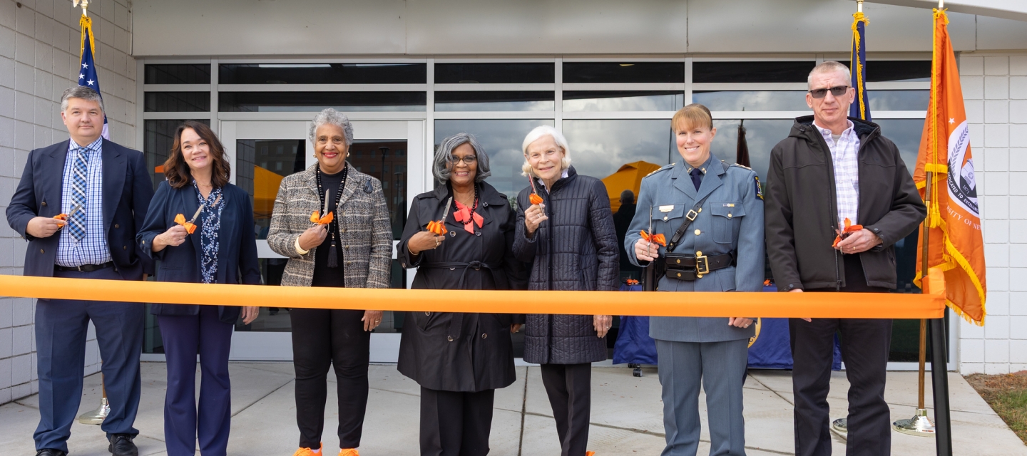 Group of seven people cutting ceremonial ribbon