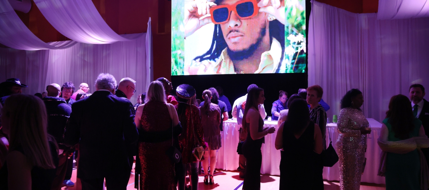 Room with event attendees and large video monitor