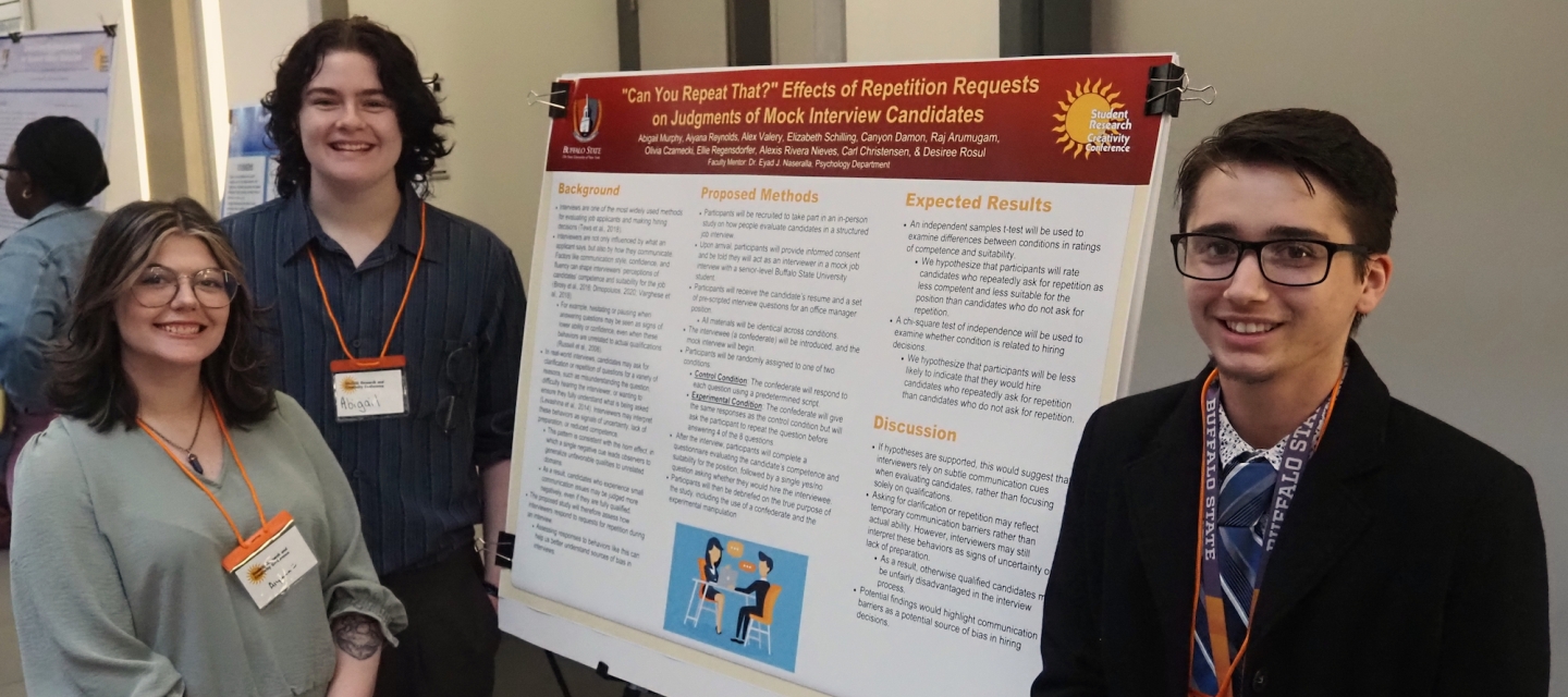 Three students with poster