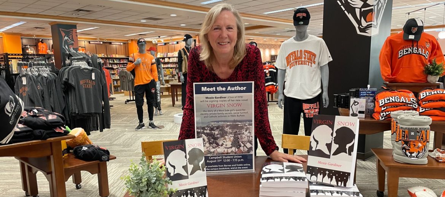 Deborah Gallagher leaning on table of books