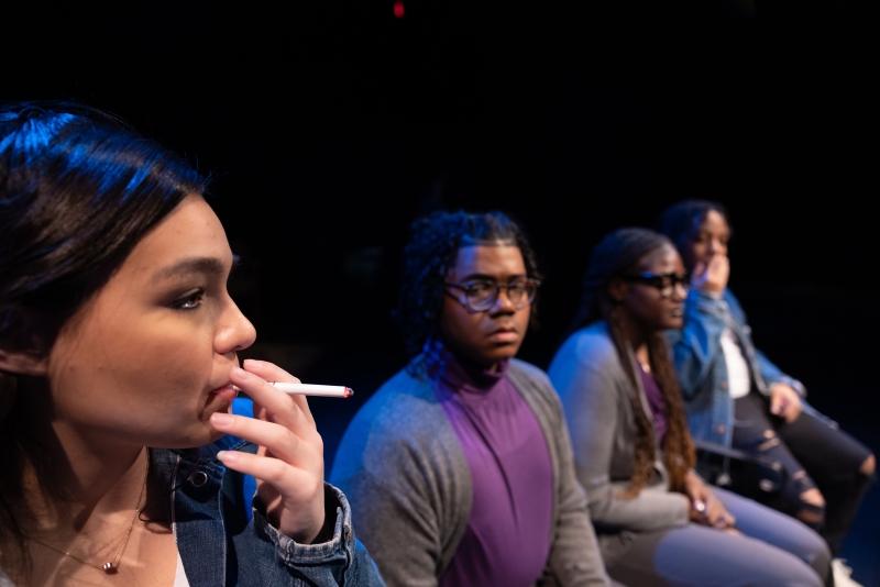 Four student actors lined up, one smoking
