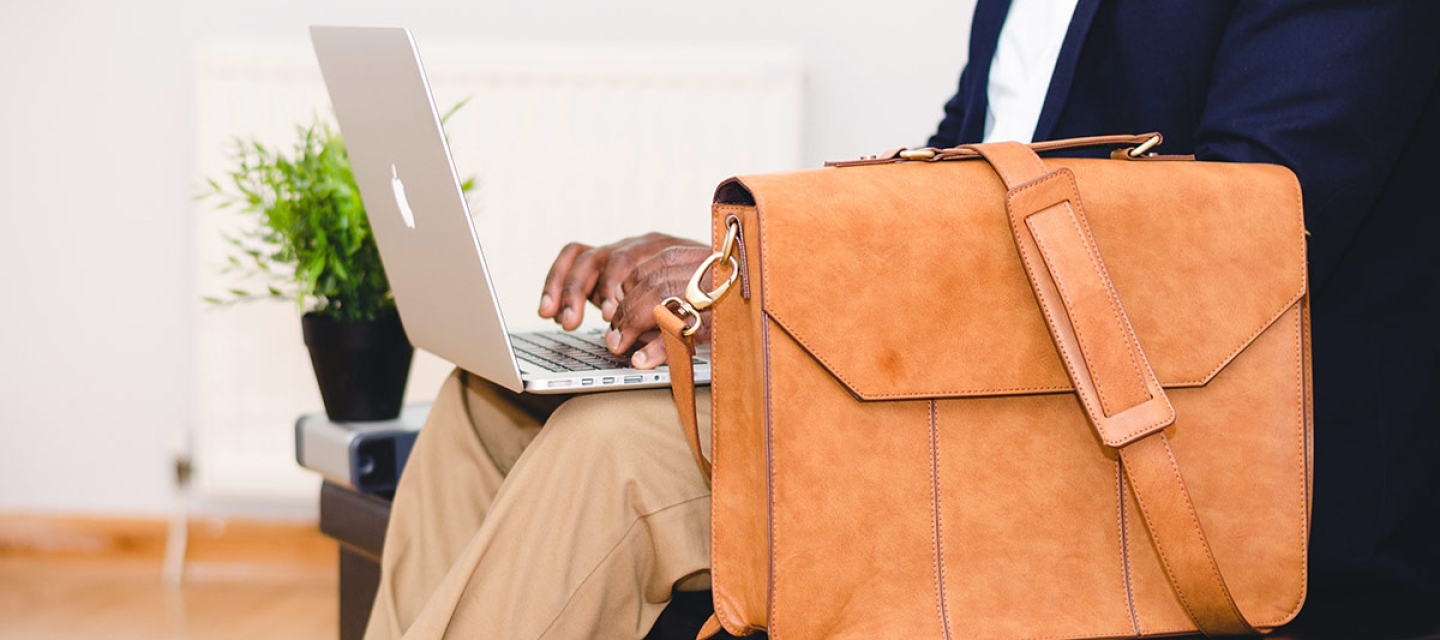 Man sitting with laptop and briefcase